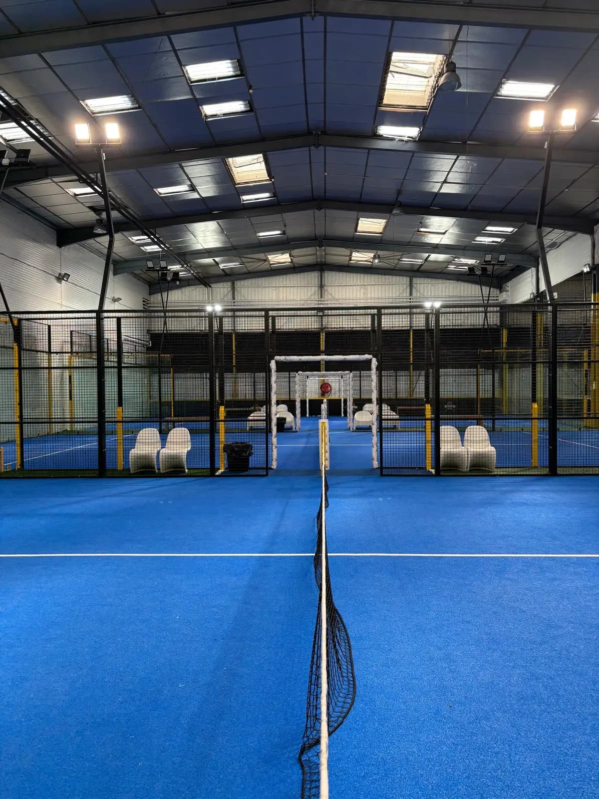 Indoor padel courts with a player's Padel Fast rating card and progression chart hovering above the court