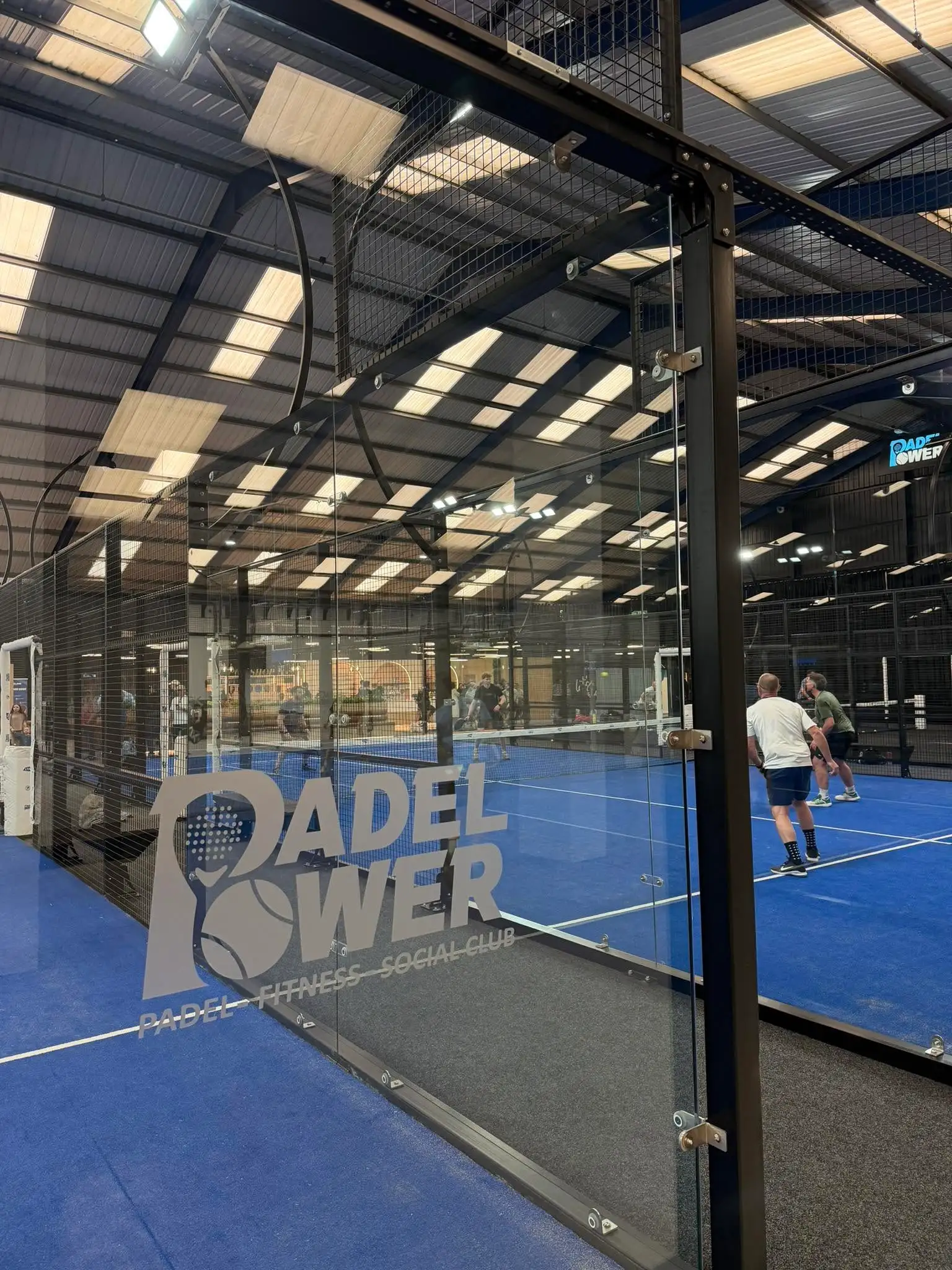 Players on an indoor padel court at a club running Padel Fast